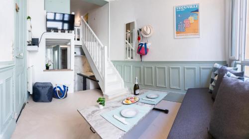 un salon avec une table et un escalier dans l'établissement CHEZ COLETTE à 3MN DE LA PLAGE avec Wifi jusqu'à 4 personnes, à Trouville-sur-Mer