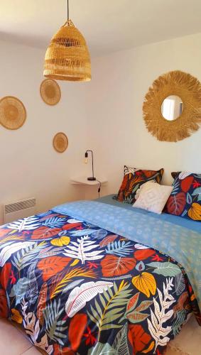 - une chambre avec un lit et une couverture colorée dans l'établissement Le Fort de l'Eve à St-Marc-Sur-Mer, à Saint-Nazaire