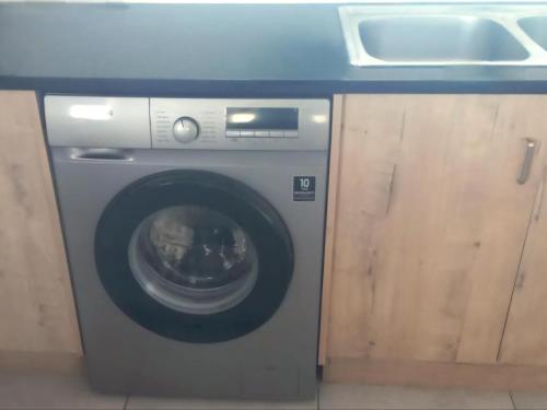a washing machine in a kitchen with a sink at Oupa Gallie in Vleesbaai in Vleesbaai