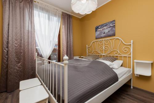 a bedroom with a white bed and a window at Jantar Apartamenty Deluxe Sea View in Kołobrzeg