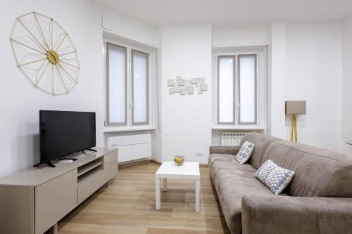 a living room with a couch and a flat screen tv at Genoa Lux Apartments with parking in Genova