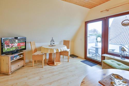 a living room with a table and a television at Ferienwohnung Heideweg, OG in Zingst