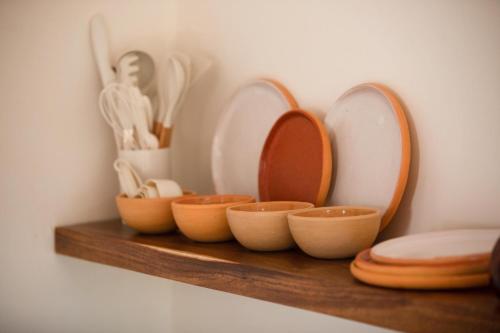 a shelf with bowls and mirrors on a wall at Amari Sayulita Boutique Hotel in Sayulita