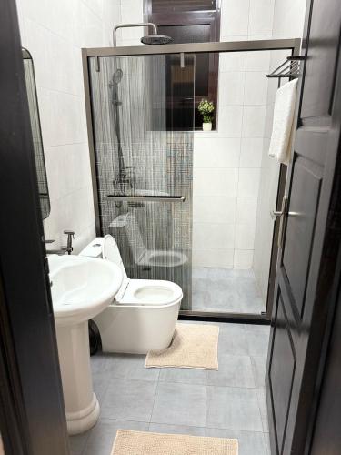 a bathroom with a toilet and a sink and a shower at Rukundo's Residence in Nalakonge