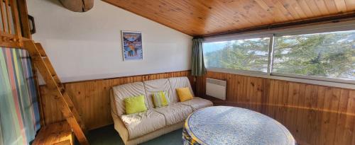 Cette petite chambre comprend un canapé et une fenêtre. dans l'établissement Studio confortable pour 4 personnes, à Chabanon Solonnet