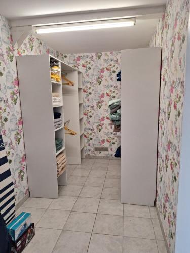 a walk in closet with white doors and floral wallpaper at Gîte Le Clos de Champagnolles in Champagnolles