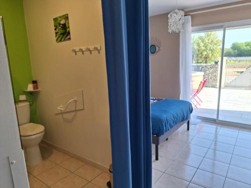 a bathroom with a bed and a toilet in a room at Gîte Le Clos de Champagnolles in Champagnolles
