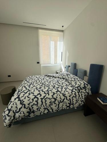 Un dormitorio con una cama con un edredón blanco y negro. en Holiday Home 63, en Nápoles