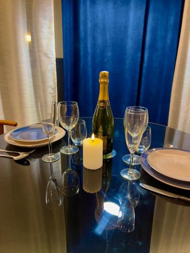 une table avec des verres et une bouteille de vin et une bougie dans l'établissement Séjour Insolite ,SPA privatif, à Troyes