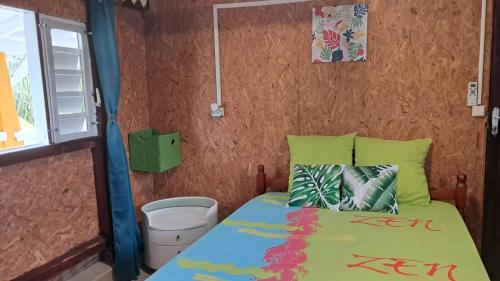 a small bedroom with a bed and a window at Le Bon Logis du Carbet in Capesterre-Belle-Eau