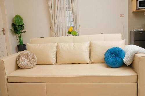 a white couch with pillows on it in a living room at Cozy 1BR Apt in Kajjansi Airstrip Entebbe in Kajansi