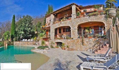 une grande maison avec une piscine devant dans l'établissement Locaspera, à Spéracèdes