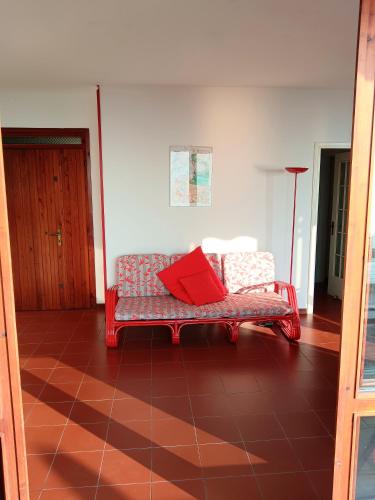 a couch in a living room with a red pillow on it at Pian delle Betulle in Torri del Benaco