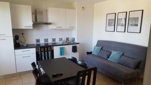 Il dispose d'une cuisine et d'un salon avec un canapé et une table. dans l'établissement Le Fort de l'Eve à St-Marc-Sur-Mer, à Saint-Nazaire