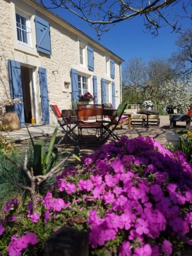 a garden with pink flowers in front of a house at Chambre d'hôtes Chez Léon pour 1 à 4 personnes in Chaulgnes