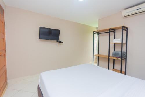 a bedroom with a bed and a tv on a wall at Hotel Tropical San Jeronimo in San Jerónimo
