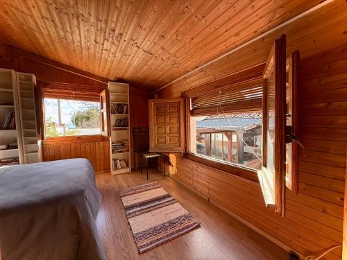 a bedroom with a bed and a window in a log cabin at Chalet en Alfacar Sierra de Huétor in Alfacar
