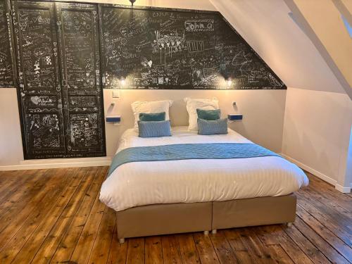 a bedroom with a bed with a chalkboard on the wall at La Tannerie de Montreuil in Montreuil-sur-Mer