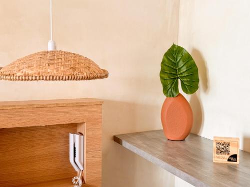 a plant in an orange vase sitting on a counter at Hotel Premium Recanto da Passagem in Cabo Frio