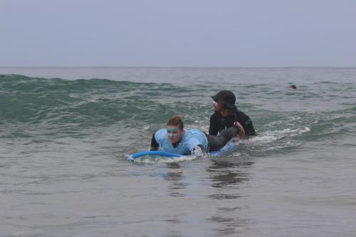two people on a surfboard in the water at Imsouane petitsurfer SurfCamp in Imsouane