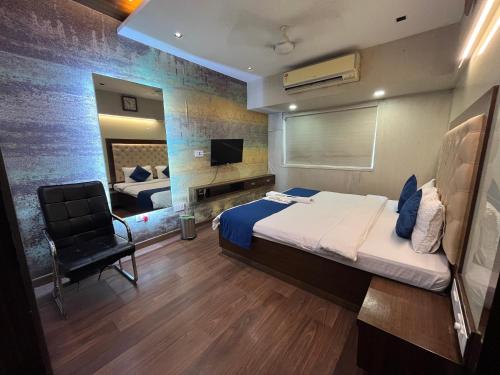 a bedroom with a bed and a chair and a mirror at Zenith Luxe Suites - Near IIT & Hiranandani, Powai in Mumbai