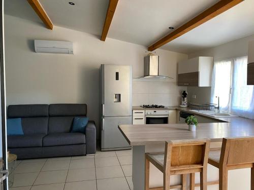 Il comprend une cuisine équipée d'une table, d'un canapé et d'un réfrigérateur. dans l'établissement Valras maison bord de mer, à Sérignan