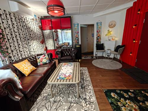 a living room with a couch and a table at Relax & Recharge - a Unique Suite with a Touch of Luxury - Hot Tub and Sauna Inspired Decor #NOT A REAL SAUNA# Easy City Access - direct train 15 min to city in Helsinki