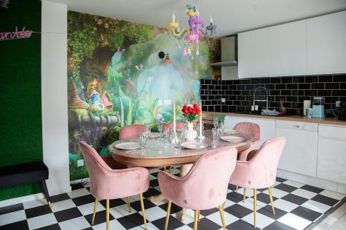 une salle à manger avec une table et des chaises roses dans l'établissement L'enchantée, 6 people, 15 min Disneyland Paris, BBQ, à Crécy-la-Chapelle