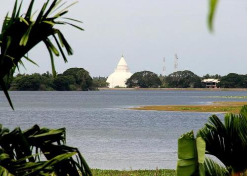 a large body of water with a building in the background at My Home Resort Yala Safari in Tissamaharama