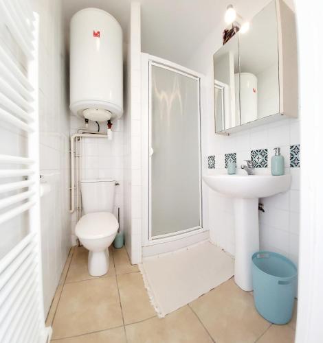 une salle de bain blanche avec des toilettes et un lavabo dans l'établissement Le Fort de l'Eve à St-Marc-Sur-Mer, à Saint-Nazaire