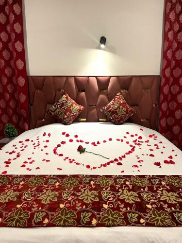 a bed with a heart made out of red roses at Meer Mansion Homestay in Srinagar