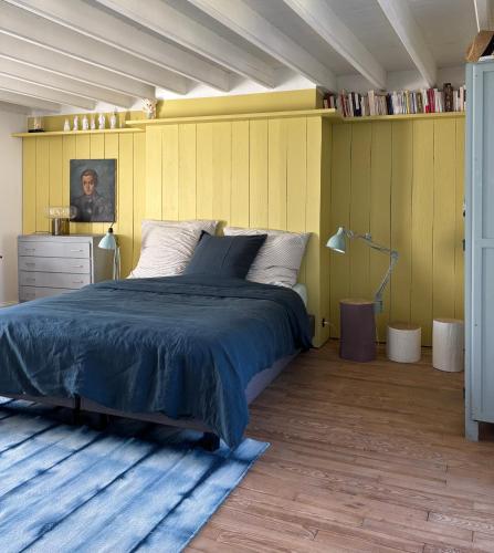 - une chambre avec un lit et un mur jaune dans l'établissement Maison de charme proche mer, à Blainville-sur-Mer