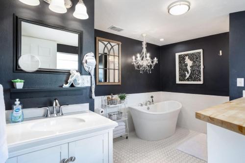 un bagno con vasca, lavandino e specchio di Romantic Cottage King Pool Pickleball Beaches a Melbourne