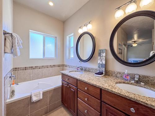 a bathroom with two sinks and a tub and a mirror at Bear Lake Escape-Pet Friendly in Garden City