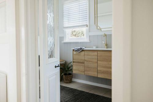 a bathroom with a sink and a window at Smiths Cottage Devonport in Devonport