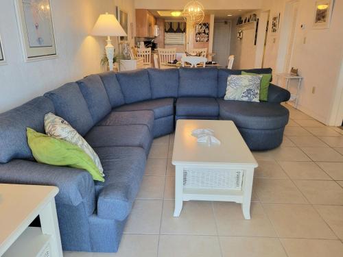 a living room with a blue couch and a table at 409 - 2/2 Stunning Condo Ocean View in New Smyrna Beach