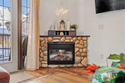 a stone fireplace in a living room with a fire place at 2BR Mystic Springs Escape with BBQ, Pool, Hot tub in Canmore