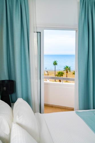 a bedroom with a bed and a view of the beach at Lazuli Sea View Beachfront Ap 21 in Larnaca