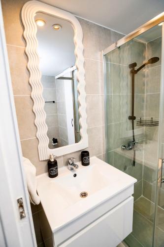 a bathroom with a white sink and a shower at Lazuli Sea View Beachfront Ap 21 in Larnaca