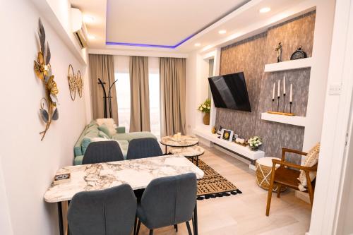 een woonkamer met een tafel en stoelen bij Lazuli Sea View Beachfront Ap 21 in Larnaka