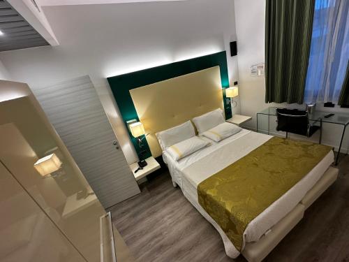 a bedroom with a large bed with a green headboard at Green Park Hotel in Peschiera del Garda