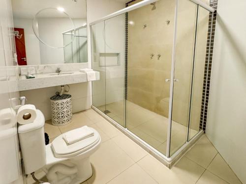 a bathroom with a glass shower and a toilet at Hotel Premium Recanto da Passagem in Cabo Frio