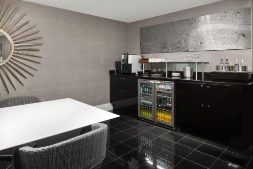a dining room with a table and a drink bar at Crowne Plaza London Ealing by IHG in London