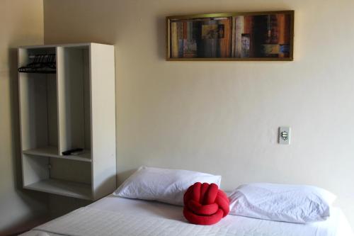a red pillow sitting on top of a bed at Atobás in Arraial do Cabo