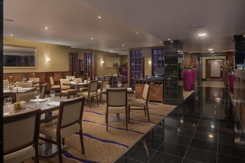 a restaurant with tables and chairs in a room at Crowne Plaza London Ealing by IHG in London