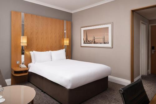 a hotel room with a large bed and a table at Crowne Plaza London Ealing by IHG in London