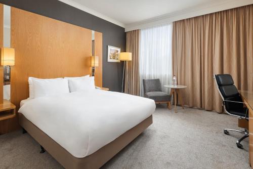 a large white bed in a hotel room at Crowne Plaza London Ealing by IHG in London
