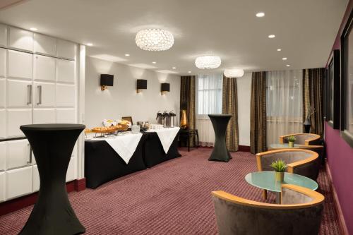 a hotel room with tables and chairs and a room with at Crowne Plaza London Ealing by IHG in London