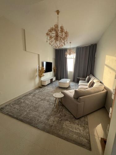 a living room with a couch and a chandelier at Luxury Two Bedroom Spacious Appartment Brand New in Ajman