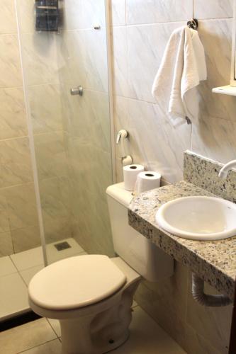 a bathroom with a toilet and a sink and a shower at Atobás in Arraial do Cabo